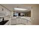 Updated kitchen featuring quartz countertops, white cabinets, and views into the living area at 2700 N Peninsula Ave # 322, New Smyrna Beach, FL 32169