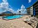 Community pool with lounge chairs and ocean views in a condo complex with a blue cabana at 2700 N Peninsula Ave # 322, New Smyrna Beach, FL 32169