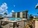 Exterior view of a community pool with lounge chairs and palm trees set against a bright blue sky at 2700 N Peninsula Ave # 322, New Smyrna Beach, FL 32169