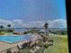 Screened in exterior view of the pool with palm trees and harbor at 2700 N Peninsula Ave # 322, New Smyrna Beach, FL 32169