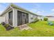 Backyard with a screened-in patio, green lawn, landscaping, and a white privacy fence at 2733 Neverland Dr, New Smyrna Beach, FL 32168