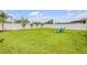 Large backyard with a well-maintained lawn, white privacy fence, and a set of Adirondack chairs at 2733 Neverland Dr, New Smyrna Beach, FL 32168