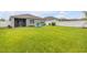 Expansive backyard with a lush lawn, white fence, and chairs offering plenty of space for outdoor activities at 2733 Neverland Dr, New Smyrna Beach, FL 32168