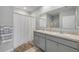 Bright bathroom featuring a double sink vanity with neutral-toned walls and a decorative shower curtain at 2733 Neverland Dr, New Smyrna Beach, FL 32168