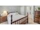Comfortable bedroom with a wooden bed frame, matching nightstands, and view into the hallway and bathroom at 2733 Neverland Dr, New Smyrna Beach, FL 32168
