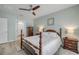 Comfortable bedroom with a wooden bed frame, matching nightstands, ceiling fan, and view into the ensuite bathroom at 2733 Neverland Dr, New Smyrna Beach, FL 32168