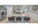 Kitchen with island seating, stainless appliances, and light gray cabinetry open to living area at 2733 Neverland Dr, New Smyrna Beach, FL 32168
