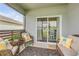 Cozy covered patio featuring comfortable wicker furniture with pineapple pillows and a sliding glass door at 2733 Neverland Dr, New Smyrna Beach, FL 32168