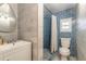 Cozy bathroom featuring a white vanity, modern fixtures, and a blue tiled shower with a window at 2900 S Peninsula Dr, Daytona Beach, FL 32118