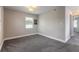 Clean bedroom with neutral walls, window, and plush gray carpeting at 2900 S Peninsula Dr, Daytona Beach, FL 32118
