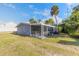 Screened in porch and lush green lawn create a welcoming outdoor space attached to the main house at 2900 S Peninsula Dr, Daytona Beach, FL 32118