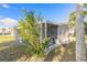 Exterior view of a screened-in porch on a well-maintained home surrounded by green vegetation at 2900 S Peninsula Dr, Daytona Beach, FL 32118
