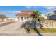 Home exterior with mature landscaping, a stone wall, a well-manicured lawn, and a paved driveway at 2900 S Peninsula Dr, Daytona Beach, FL 32118