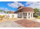 Charming home exterior with mature landscaping, a manicured lawn, and brick-lined driveway at 2900 S Peninsula Dr, Daytona Beach, FL 32118