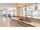 Modern kitchen featuring a marble countertop, stainless steel sink, and an open view to the living area at 2900 S Peninsula Dr, Daytona Beach, FL 32118