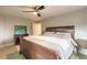 Spacious main bedroom featuring a wooden bed frame, ceiling fan, and a view of colorful painting on the wall at 2900 S Peninsula Dr, Daytona Beach, FL 32118