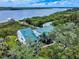 Aerial view showcasing the home's waterfront location, metal roof, and lush surroundings at 2950 Sunset Dr, New Smyrna Beach, FL 32168