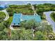 Birds eye view of a home with a metal roof near water and a private dock surrounded by lush greenery at 2950 Sunset Dr, New Smyrna Beach, FL 32168