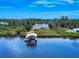 Expansive waterfront property featuring a house and boat dock, embraced by lush greenery at 2950 Sunset Dr, New Smyrna Beach, FL 32168