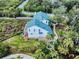 Aerial perspective highlighting a metal roof and beautiful landscaping on the property at 2950 Sunset Dr, New Smyrna Beach, FL 32168