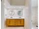 Bathroom featuring a modern vanity with double sinks, round mirrors, and a tiled shower nearby at 2950 Sunset Dr, New Smyrna Beach, FL 32168