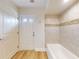 Bathroom showcasing bathtub, tiled walls, and a door to the exterior at 2950 Sunset Dr, New Smyrna Beach, FL 32168