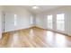 Bright bedroom featuring wood-look floors, double doors to a balcony, and a vaulted ceiling at 2950 Sunset Dr, New Smyrna Beach, FL 32168