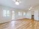 Bright bedroom with two ceiling fans, wood floors, shuttered windows, and exterior door to balcony at 2950 Sunset Dr, New Smyrna Beach, FL 32168