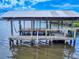 Waterfront boat dock featuring lounging area and ladder for swimming, offering a relaxing space at 2950 Sunset Dr, New Smyrna Beach, FL 32168