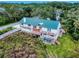 Stunning elevated home with a green metal roof and multiple decks overlooking lush surroundings at 2950 Sunset Dr, New Smyrna Beach, FL 32168