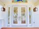 Elegant front door with glass panes and sidelights, adorned with a mosaic and stylish lanterns at 2950 Sunset Dr, New Smyrna Beach, FL 32168