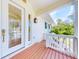 Welcoming front entrance with a glass door, charming lantern and warm-toned wooden porch at 2950 Sunset Dr, New Smyrna Beach, FL 32168