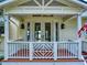 Inviting front porch with a decorative railing and double doors, creating a warm welcome at 2950 Sunset Dr, New Smyrna Beach, FL 32168