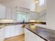 Bright kitchen with white cabinets, granite countertops, an island, stainless steel sink, and pendant lighting at 2950 Sunset Dr, New Smyrna Beach, FL 32168