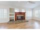 Cozy living room features custom built-ins, a stone fireplace, and ample natural light through shuttered windows at 2950 Sunset Dr, New Smyrna Beach, FL 32168