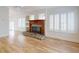Spacious living room featuring a stone fireplace, wood floors, and natural light from the windows at 2950 Sunset Dr, New Smyrna Beach, FL 32168