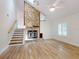 Living room featuring vaulted ceilings, a stone fireplace, wood flooring, and a staircase at 2950 Sunset Dr, New Smyrna Beach, FL 32168
