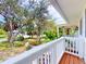 Scenic porch view showing large trees, tropical foilage and landscaping, creating a park-like setting at 2950 Sunset Dr, New Smyrna Beach, FL 32168