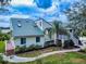 View of the back of the home with a metal roof, private deck, landscaping, and walkway at 2950 Sunset Dr, New Smyrna Beach, FL 32168