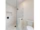 Contemporary shower featuring white marble tile, glass partition, and pebble flooring at 2950 Sunset Dr, New Smyrna Beach, FL 32168