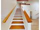 View of a wood and white staircase with wood-look flooring and natural light at 2950 Sunset Dr, New Smyrna Beach, FL 32168