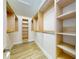 Walk-in closet featuring wood-look flooring and custom shelving at 2950 Sunset Dr, New Smyrna Beach, FL 32168