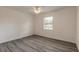 Bright bedroom with ceiling fan, window, and wood-look flooring at 3044 Pine Tree Dr, Edgewater, FL 32141