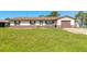 Charming single-story home with a well-maintained lawn, brown accents, and an attached garage at 3044 Pine Tree Dr, Edgewater, FL 32141