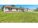 Classic single-story home featuring a well-manicured front lawn, brown trim, and an attached garage at 3044 Pine Tree Dr, Edgewater, FL 32141