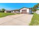 Cozy single-story home with a lush lawn, brown accents, and an attached one car garage at 3044 Pine Tree Dr, Edgewater, FL 32141