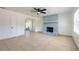 Bright living room features tile floors, a ceiling fan, and a painted brick fireplace at 3044 Pine Tree Dr, Edgewater, FL 32141