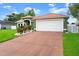 A ranch style home with an attached garage, lush landscaping, and a charming front entrance at 3231 Bretton Woods Ter, Deltona, FL 32725