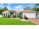 Charming front exterior with lush landscaping, manicured lawn, and a walkway leading to the front door at 3231 Bretton Woods Ter, Deltona, FL 32725