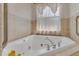 Close up of a soaking tub with jets, and a window with sheer curtains at 3326 S Peninsula Dr, Port Orange, FL 32127